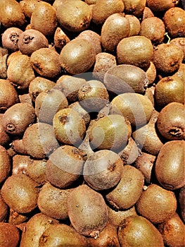 Vertical closeup shot of many kiwi fruits