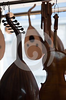 Vertical closeup shot of an oud and a violin with other musical instruments in the background