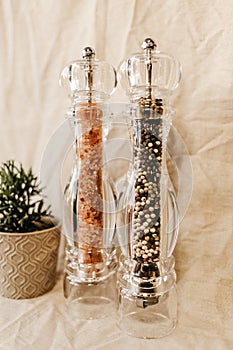 Vertical closeup shot of pepper and salt grinders on a table