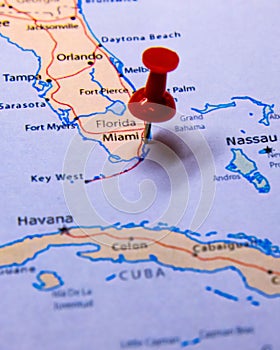 Vertical closeup shot of a red location push pin on the city of Miami on a map