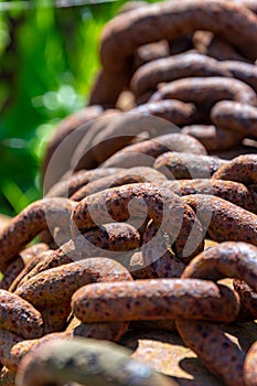 Vertical closeup shot of rusty brown chains on a pole