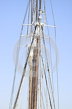 Vertical closeup shot of sailing boat mast and rigging details with a clear sky behind