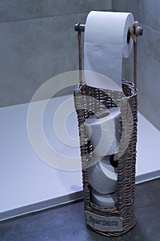 Vertical closeup shot of toilet papers on a straw stand in the bathroom