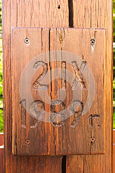 Vertical closeup shot of a wooden board with 21X 1989 y. carving