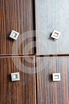 Vertical closeup shot of a wooden closet with four doors with small square handles