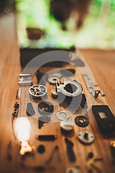 Vertical closeup of small pieces of metallic parts on the wooden background