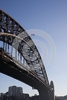 Vertical closeup of the Sydney Harbour Bridge in the daytime with the Australian flag on it