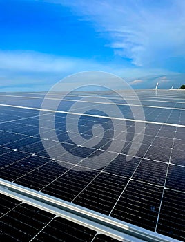 Vertical closeup of symmetrical solar panels with blue sky on the background