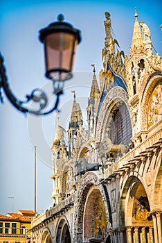 Vertical closeup of top part of facade of Basilica and Cathedral of San Marco in Venice, Italy, with vintage lamp. Travel tourism