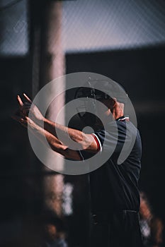 Vertical closeup of an umpire calling ball and strikes with head gestures captured from the side