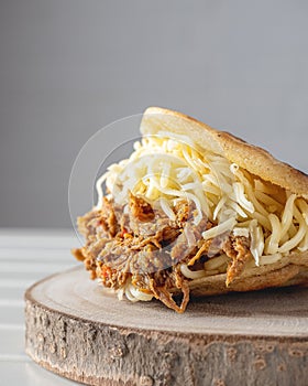 Vertical closeup of Venezuelan dish of carne mechada in arepa photo