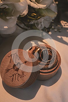 Vertical closeup of wedding bands in an adorable wooden box