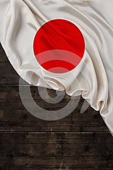 Vertical color national flag of modern state of Japan, beautiful silk, background old wood, concept of tourism, economy, politics