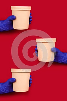 Vertical composition with hands wearing blue disposable protective gloves on red background holding round paper food