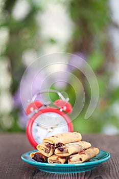 Vertical composition: a plate of fried spring rolls and an alarm clock