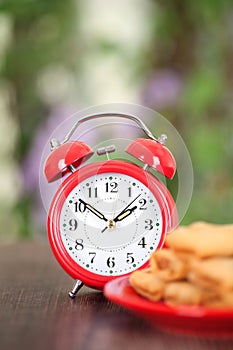 Vertical composition: a plate of fried spring rolls and an alarm clock