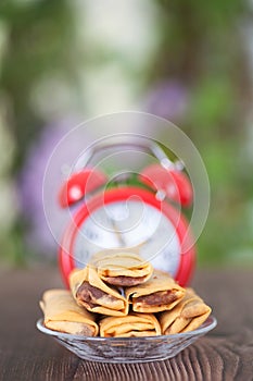 Vertical composition: a plate of fried spring rolls and an alarm clock