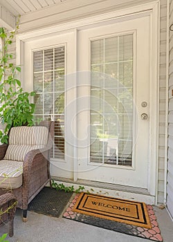 Vertical Cottage pane front door wicker armchairs and stairs viewed at the home entrance