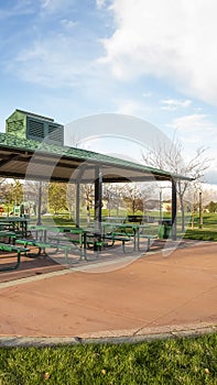 Vertical Covered picnic area on a scenic park under cloudy blue sky