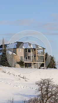 Vertical crop Wasatch Mountains snowy neighborhood with beautiful house against blue sky