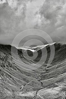 Vertical dark drone shot of rocky hills of Khardung la in Ladakh, India under cloudy sky photo