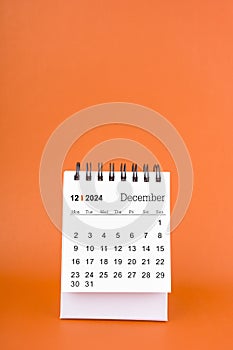 Vertical of December 2024 table calendar on orange background