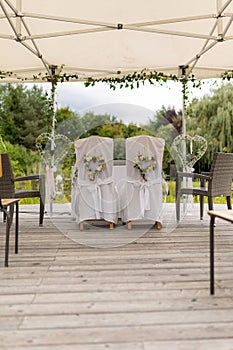 Vertical of decorated chairs in an outdoor hall on a wedding day