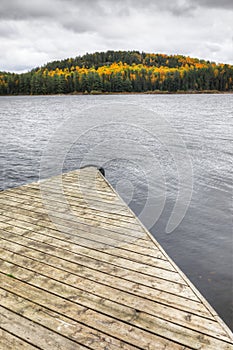 Vertical of dock with beautiful fall color at Algonquin Provincial Park, Canada