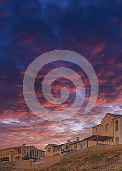 Vertical Dramatic sunset with clouds Fenced residential buildings on top of a hill at San Diego, Cali