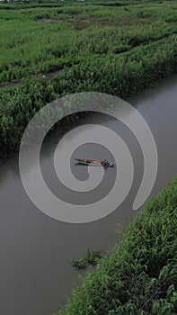 Vertical Drone Footage of Small Fishing Boats Floating on the River in the Forest