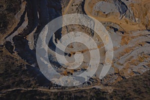 Vertical drone panorama of open mine or quarry on a sunny day at Verd, Slovenia. Visible terraces and vast surface of sand and photo