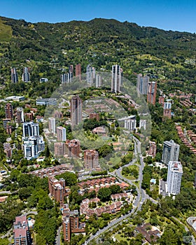 Vertical drone shot of a downtown El Poblado in Medellin with green-covered hills on background photo