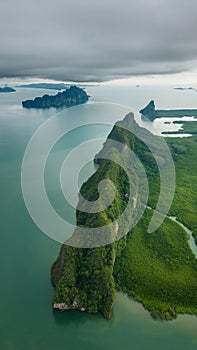 Vertical drone shot of a forested limestone mountain in Phang Nga bay, Thailand