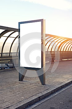 Vertical empty billboard placeholder template on the city bus stop outdoor, information banner template, space for mockup layout