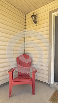 Vertical Entrance of a home with gray front door and red wooden chair on the porch