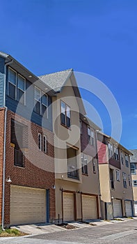 Vertical Exterior of homes with wooden and red brick wall against blue sky on sunny day
