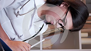 Vertical female doctor medical diagnosis paperwork