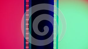 Vertical film strip on a red and green background, close up. 35mm film slide frame. Long, retro film strip frame. Copy