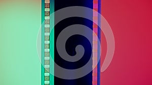 Vertical film strip on a red and green background, close up. 35mm film slide frame. Long, retro film strip frame. Copy
