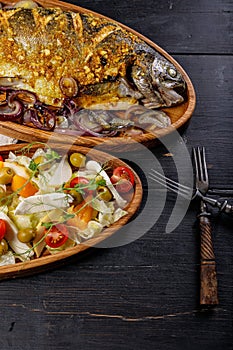 Vertical foodphoto grilled fish and vegetable salad with mozzarella. Seafood and salad with vegetables, olive oil and green olives photo