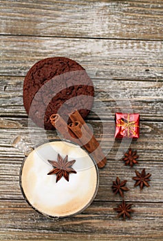 Vertical format Cappuccino and cookie with star ansie and cinnamon stick Jingle bell and gift