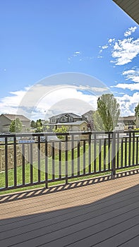 Vertical frame Balcony overlooking the yard houses and blue sky with clouds on a sunny day