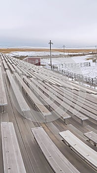 Vertical frame Bleachers overlooking a sports field covered with snow in winter
