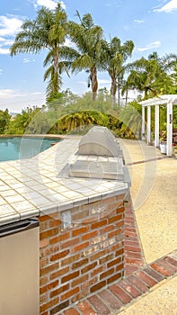 Vertical frame Day shot of a wonder California home with a large pool and counter space for a barbeque on a bright sunny