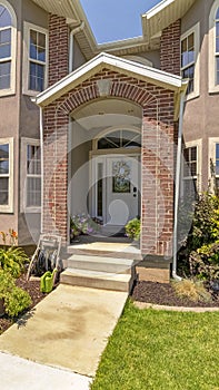 Vertical frame Entrance with red brick wall and white door with sidelights and transom window