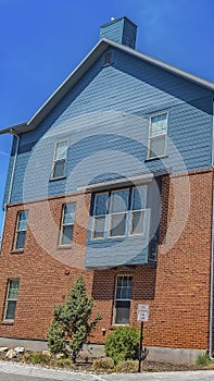 Vertical frame Exterior of homes with wooden and red brick wall against blue sky on sunny day