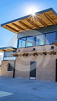 Vertical frame Facade of building with flat roof and brick wall against blue sky on a sunny day