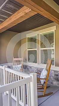 Vertical frame Facade of a home with rocking chairs on the porch and wreath on the front door