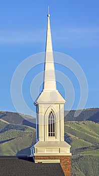 Vertical frame Focus on the roof and steeple of a church with classic red brick exterior wall