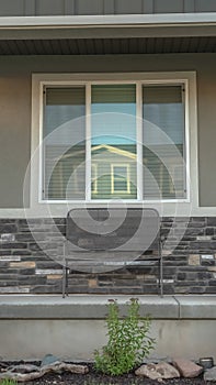 Vertical frame Front porch and yard of a family home with concrete outdoor stairs and gray door